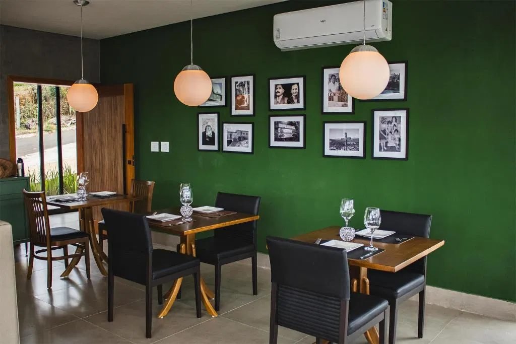 Restaurante com parede verde e fotos de família